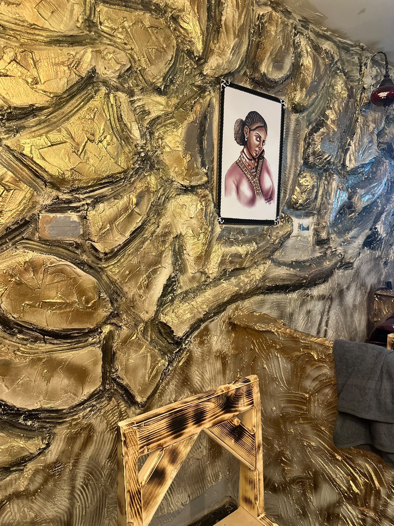 Framed East African portrait and warm gold wall textures inside LAZA