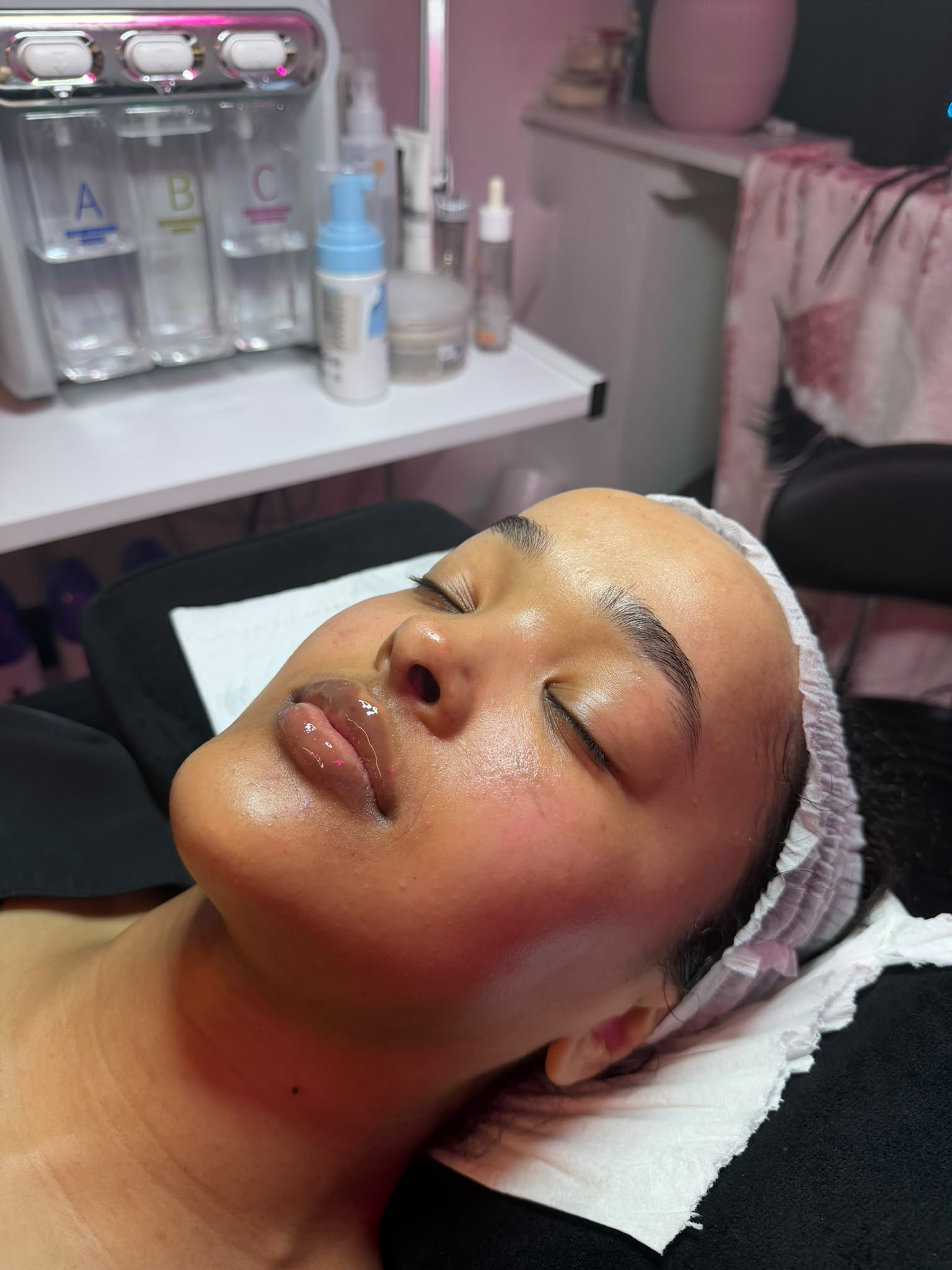 A guest resting on a treatment bed after a facial at LAZA